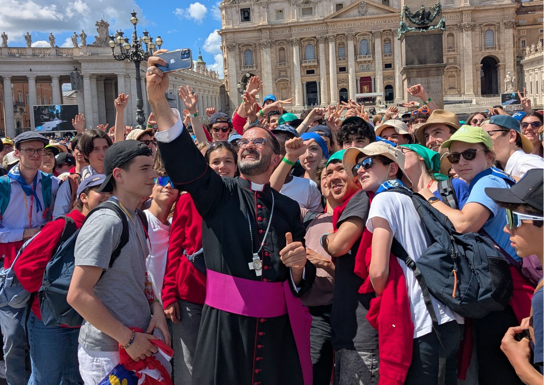 Mgr Loïc Lagadec prend un selfie avec un groupe d'adolescents devant la place Saint-Pierre de Rome